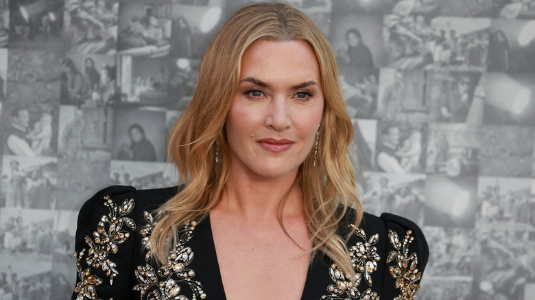 Une photo en gros plan de Kate Winslet sur le tapis rouge, portant un haut perlé, noir en V