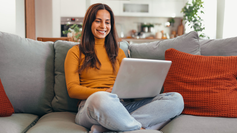 Femme sur le canapé avec son ordinateur
