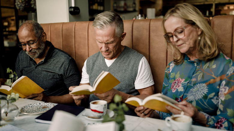 Personnes dans un livre de lecture du café