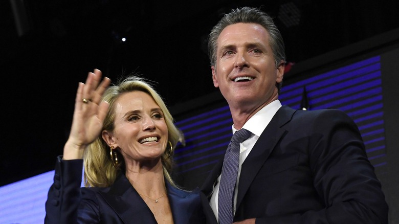 Jennifer Siebel Newsom agitant à côté de Gavin Newsom