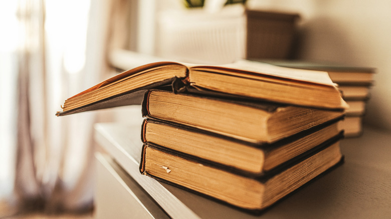 Livre altéré assis ouvert sur une pile de livres