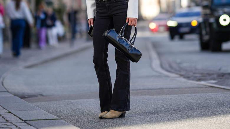 Femme portant une veste blanche et un jean noir