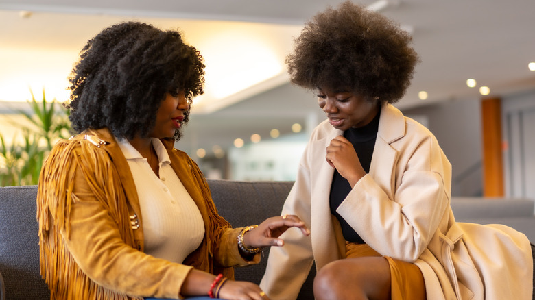 Deux femmes parlant sur un canapé
