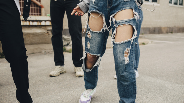 Femme portant des jeans déchirés