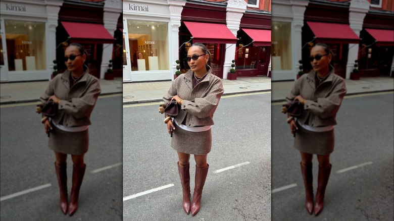 Une femme dans la rue avec une jupe et une veste assorties en tweed marron