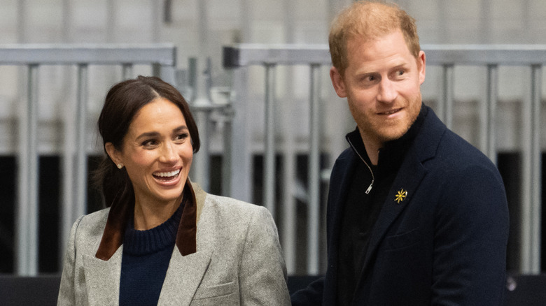 Le prince Harry et Meghan Markle passant devant l'escrime en métal