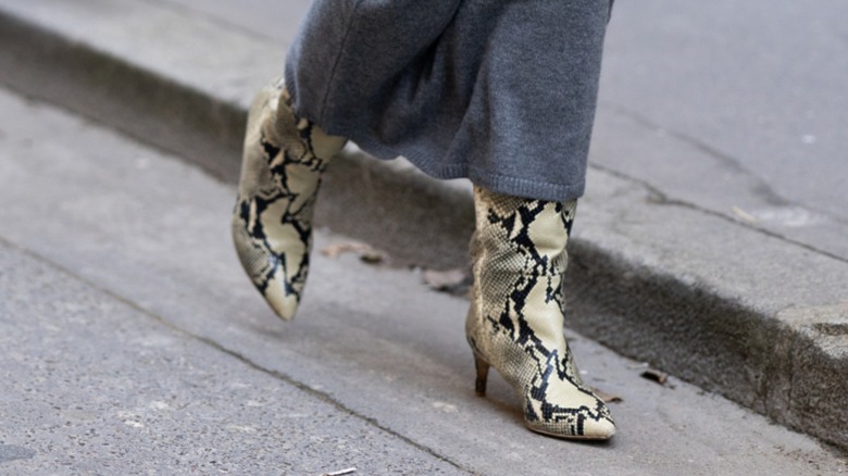 Une femme portant des bottes en peau de serpent