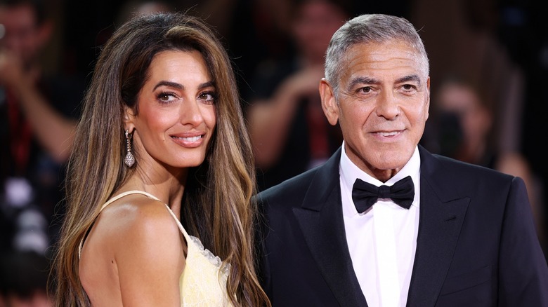 Amal Clooney souriante à côté de George Clooney sur le tapis rouge