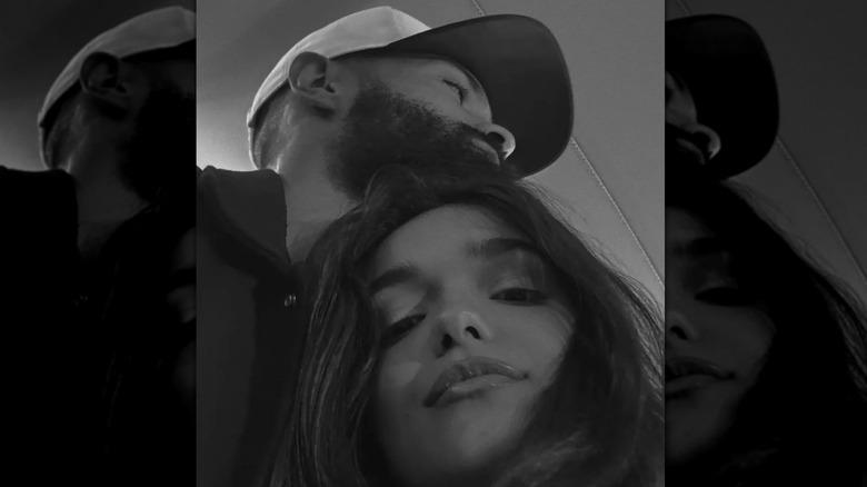 Un selfie en noir et blanc de Rachel Zegler serrant Nathan Louis-Fernand dans ses bras