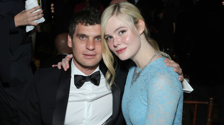 Elle Fanning en robe bleue assise sur les genoux de Gus Wenner