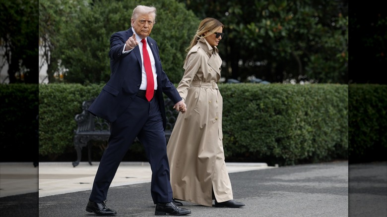 Melania et Donald Trump se tiennent la main en quittant la Maison Blanche avec elle en trench-coat