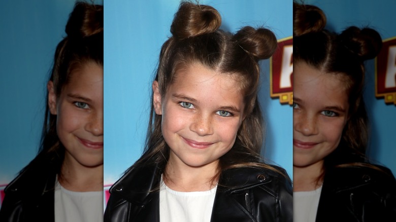 Raegan Revord souriant tout en portant un demi-chignon avec des petits pains spatiaux en 2018