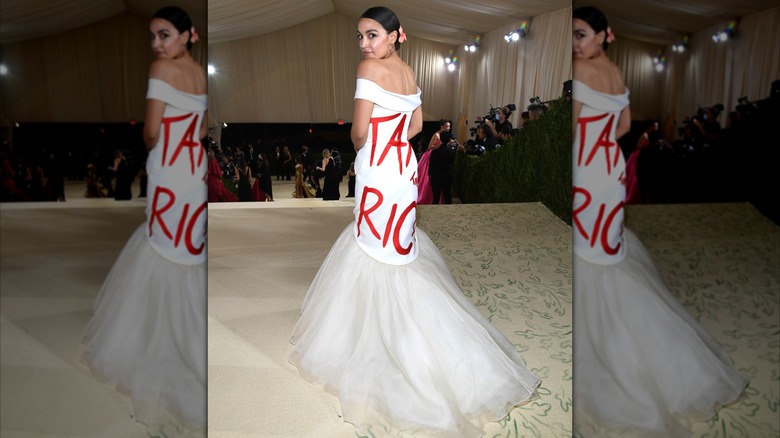 Alexandria Ocasio-Cortez dans une robe blanche avec des lettres rouges 