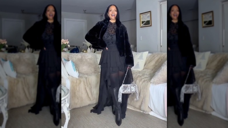 Une femme tenant un sac argenté avec une tenue noire