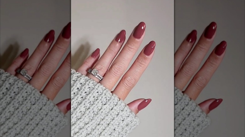 Une main avec des ongles ovales mauve foncé