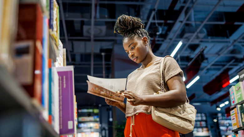 Femme âgée souriante profitant d'un moment paisible tout en lisant un livre dans son salon confortable
