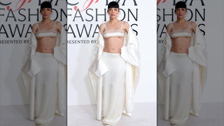 Lily Allen dans une tenue blanche avec un soutien-gorge blanc lors d'un événement