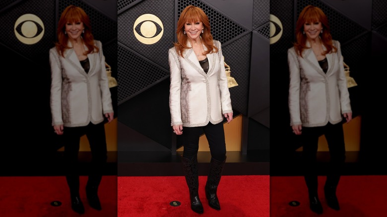 Une image du corps entier de Reba McEntire aux Grammys 2026, montrant son blazer argenté et son pantalon noir
