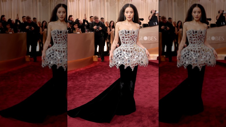 Chase Infiniti posant aux Golden Globes dans une robe à basque effet miroir avec une jupe noire