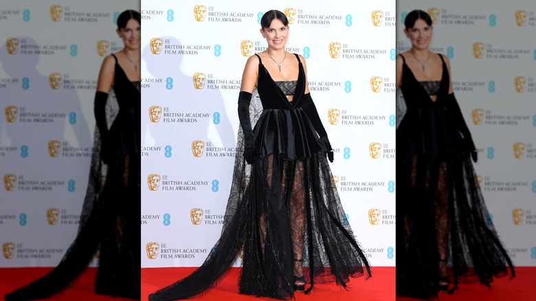 Millie Bobby Brown dans une robe en dentelle noire et des gants noirs