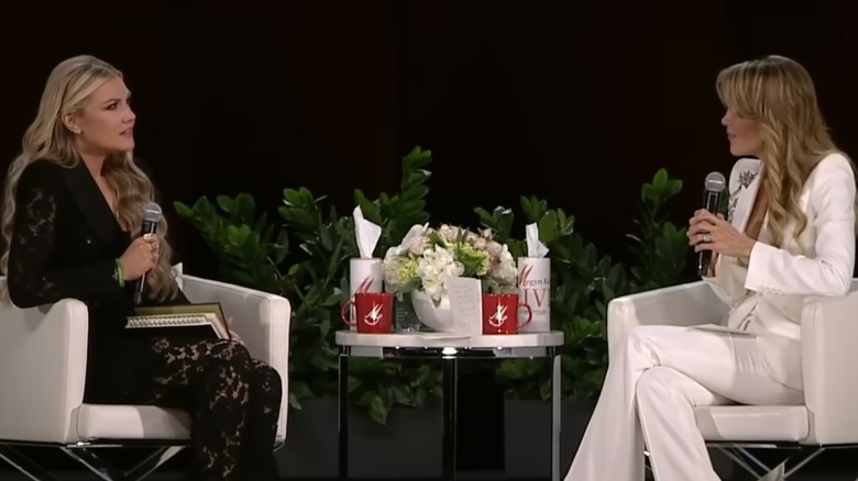 Erika Kirk dans un tailleur-pantalon en dentelle sur scène avec Megyn Kelly