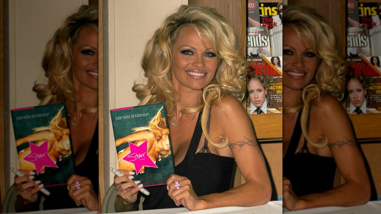 Pamela Anderson tenant un exemplaire de son livre Star