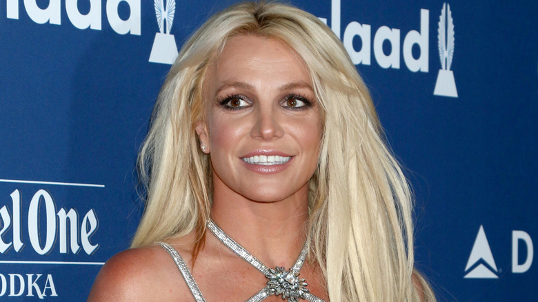 Britney Spears souriante dans une robe argentée