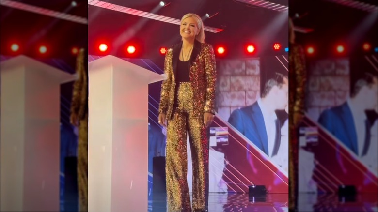 Erika Kirk dans un tailleur-pantalon doré lors d'une convention Turning Point USA