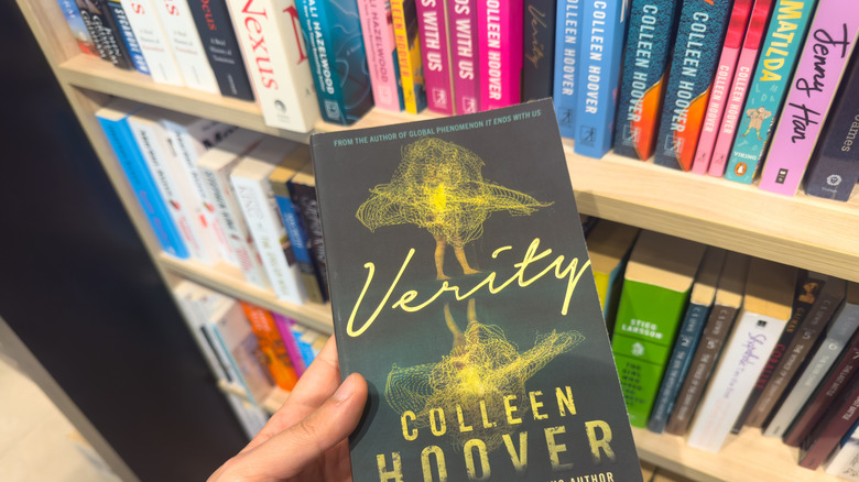 Femme tenant Verity par Colleen Hoover