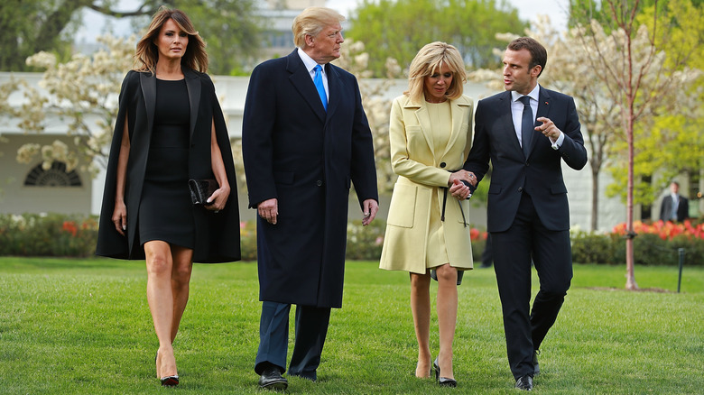 Melania Trump, le président américain Donald Trump, Brigitte Macron et le président français Emmanuel Macron traversent la pelouse sud avant de participer à une cérémonie de plantation d'arbres à la Maison Blanche le 23 avril 2018.