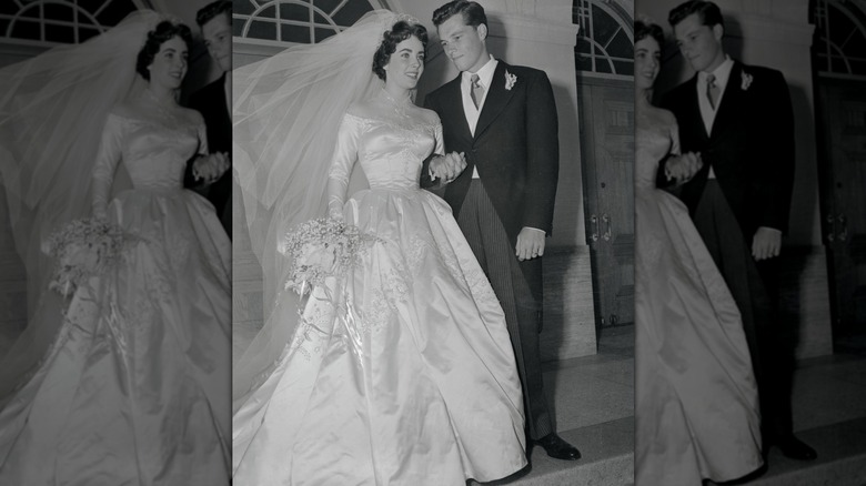 Elizabeth Taylor photographiée dans une robe de mariée en satin tout en tenant la main de son nouveau mari Conrad Nicholson Hilton Jr.