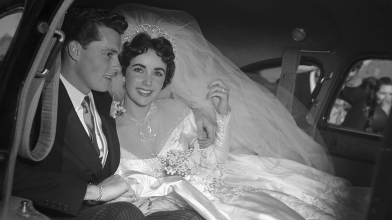 Elizabeth Taylor souriant à la caméra alors qu'elle était dans une voiture avec le marié Conrad Nicholson Hilton Jr.