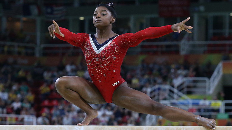 Simone Biles porte un justaucorps rouge à la poutre aux Jeux olympiques de Rio 2016