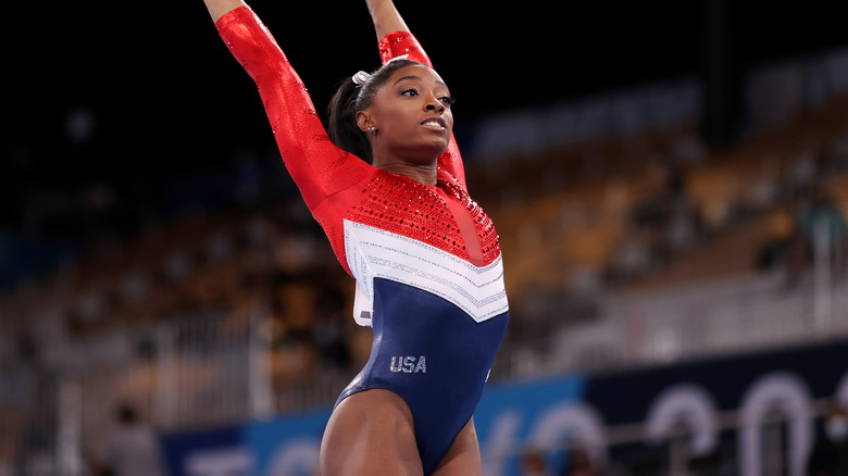 Simone Biles porte un justaucorps rouge, blanc et bleu aux Jeux olympiques de Tokyo en 2021