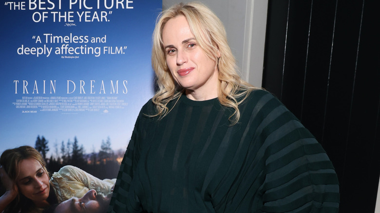 Rebel Wilson dans une robe rayée avec les cheveux détachés et bouclés