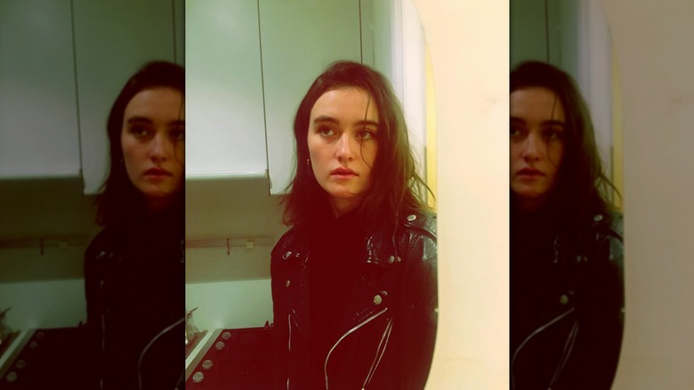 Sarah Pidgeon posant avec ses cheveux bruns portés sur un côté en désordre