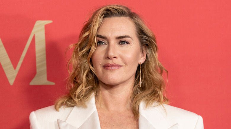 Kate Winslet sourit dans un blazer blanc