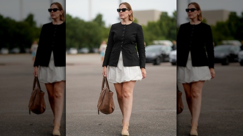 Femme portant une veste noire et une jupe bulle blanche