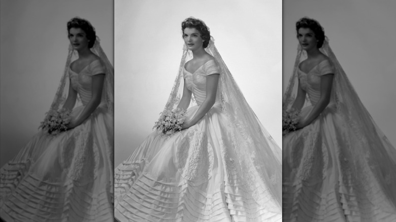 Jacqueline Kennedy assise et portant une robe de mariée avec une jupe princesse