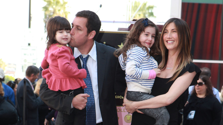 Adam Sandler tient Sunny Sandler et Jackie Sandler tient Sadie Sandler sur le tapis rouge