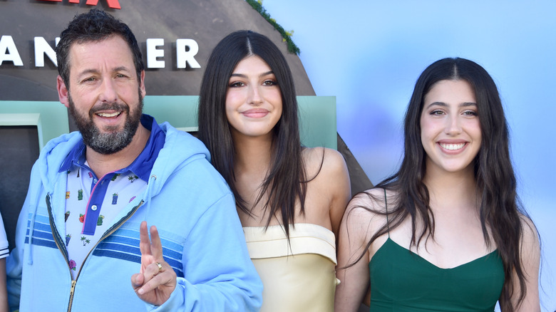 Adam Sandler, Sunny Sandler et Sadie Sandler sourient tous sur le tapis rouge