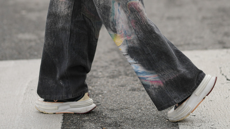 Gros plan d'une femme portant un jean noir avec des baskets épaisses et épaisses
