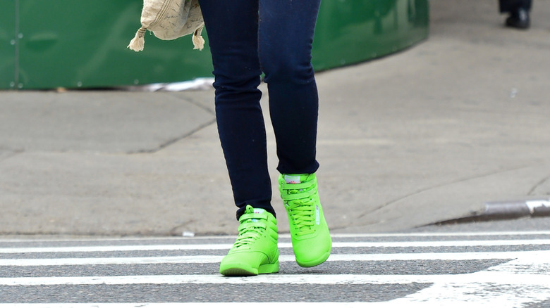 Une femme portant des baskets vert fluo traversant la rue