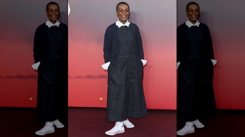 Adjoa Andoh posant sur le tapis rouge dans une robe en jean et des Chuck Taylor blanches