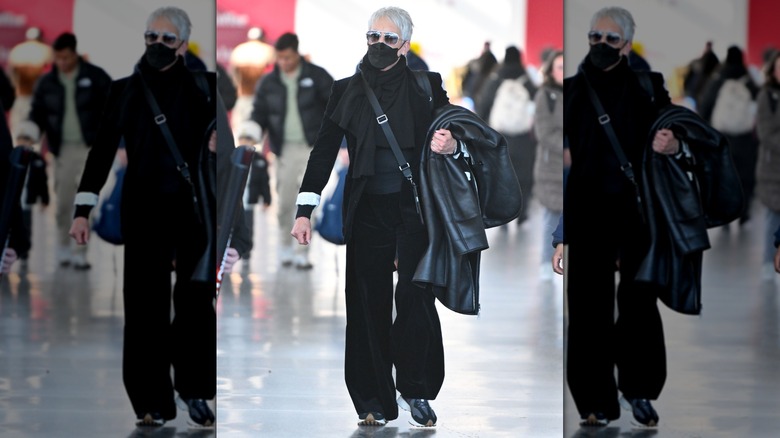 Jamie Lee Curtis porte une tenue entièrement noire avec des chaussures de sport grises, noires et blanches