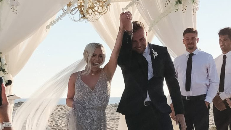 Jessi Draper et Jordan Ngatikaura se tiennent la main le jour de leur mariage