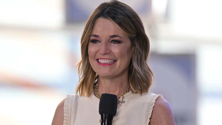 Savannah Guthrie sourit légèrement tout en tenant un microphone