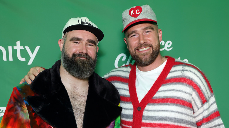 Travis et Jason Kelce portent des tenues aux couleurs vives devant un step-and-repeat
