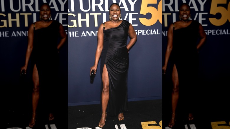 Leslie Jones souriant à la célébration du SNL50 tout en portant une robe fendue et des talons à lanières