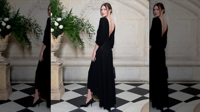 Karlie Kloss regarde par-dessus son épaule tout en faisant sauter sa jambe lors d'un appel photo Dior